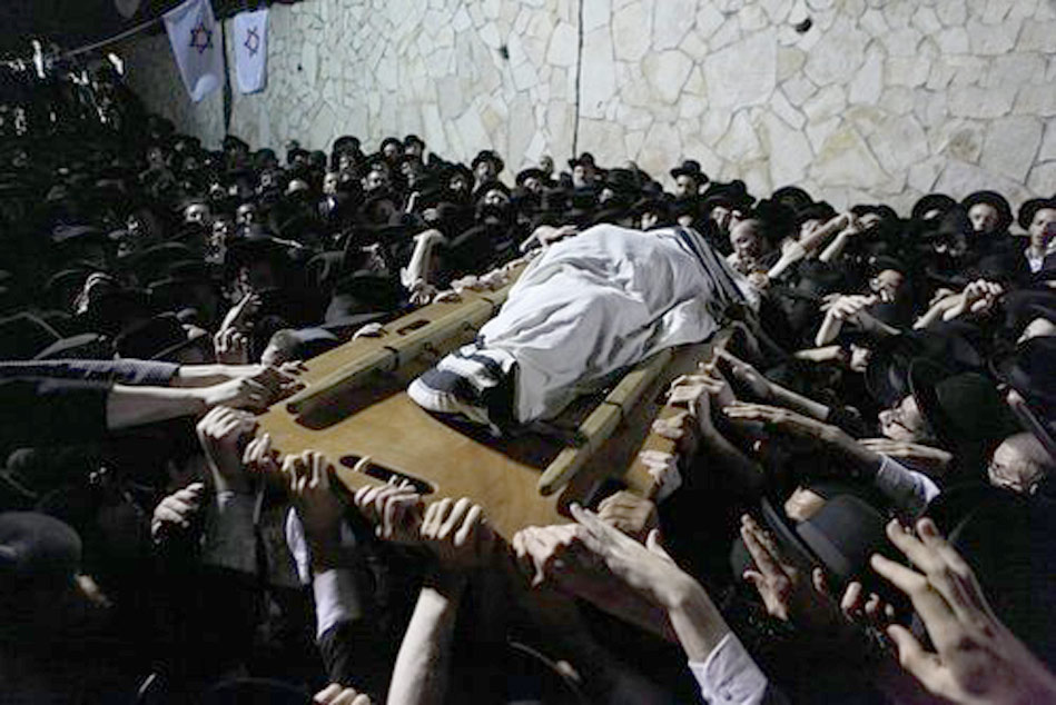 27. Le corps du Rav semble littéralement voler au dessus de la nombreuse foule qui crie sa douleur.
