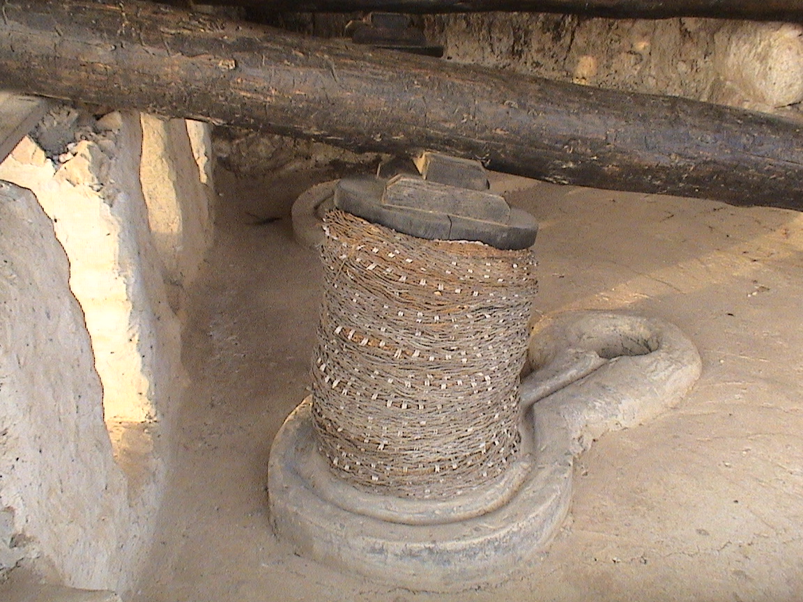 9. . Gros plan sur l'enceinte de pressage( en cordage), la rigole d'écoulement et le puits de récupération.